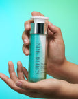 Soteri Skin Balancing Act with colorful background air tight bottle held in hands